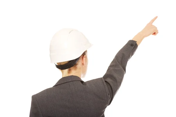Affärskvinna i hård hatt pekar uppåt. — Stockfoto