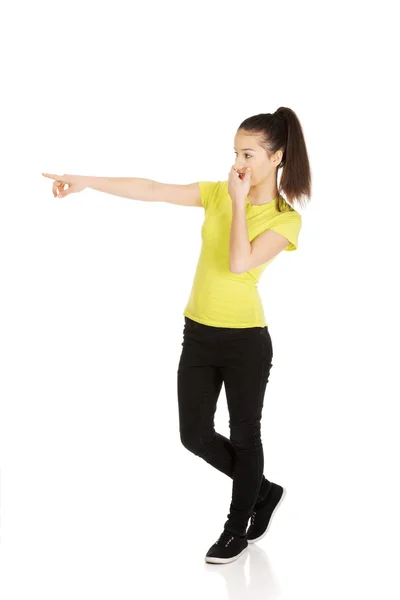 Young shocked woman pointing aside. — Stock Photo, Image