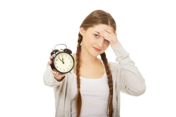 Tired teenage woman with alarmclock. — Stock Photo, Image