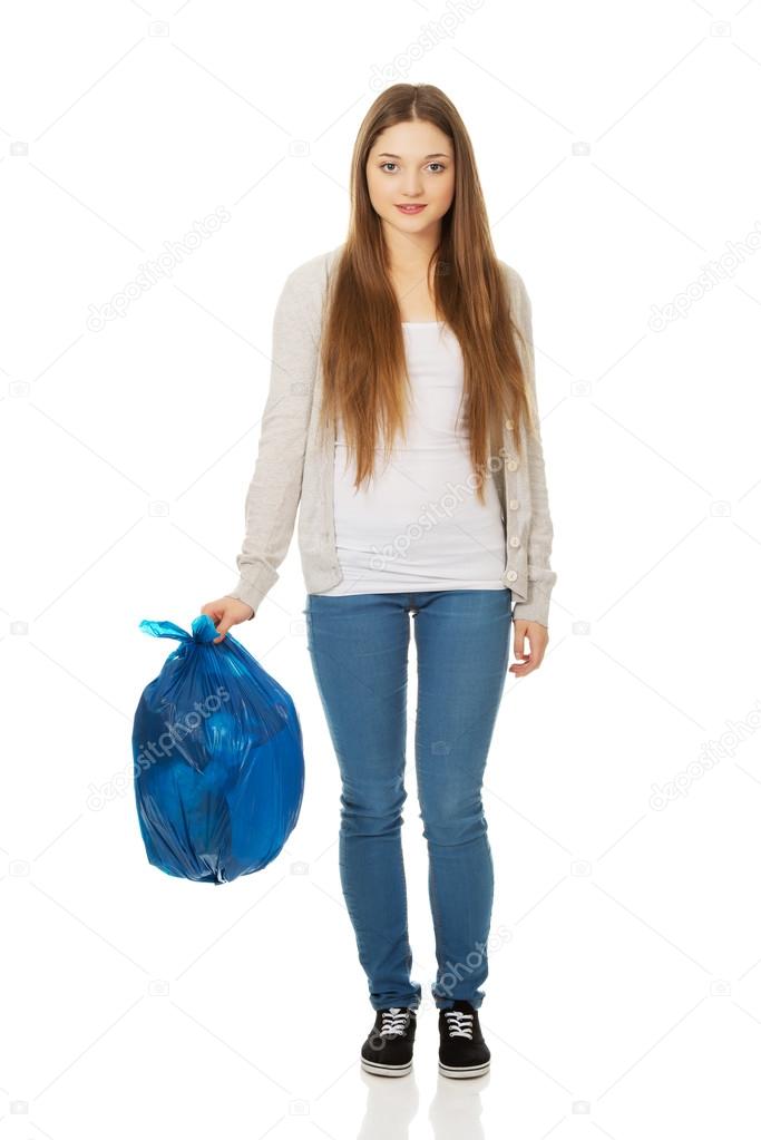 Happy woman holding a full garbage bag.
