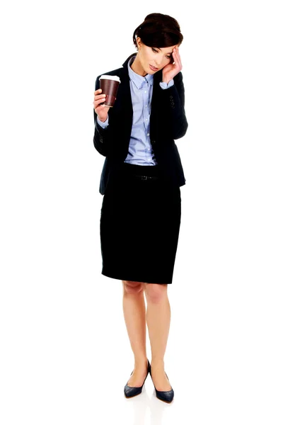 Tired businesswoman holding a cup of coffee. — Stock Photo, Image