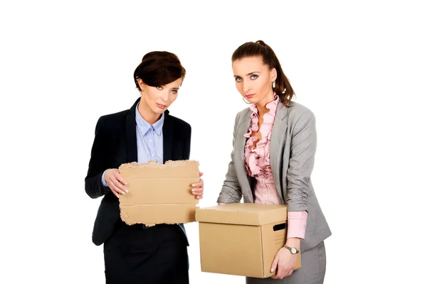 Two sad businesswoman carrying box. — Stock Photo, Image