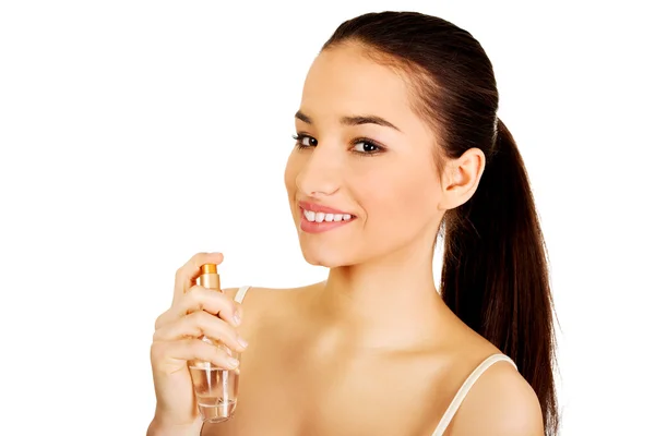 Молода жінка застосовує парфуми . — стокове фото