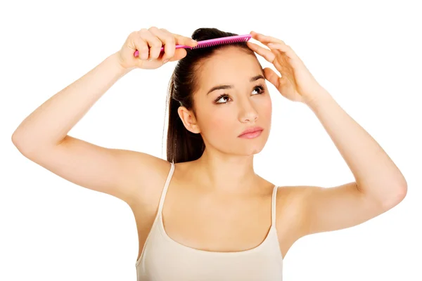 Schöne Frau kämmt ihre Haare. — Stockfoto