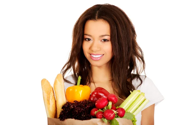 Jeune femme avec épicerie et légumes . — Photo