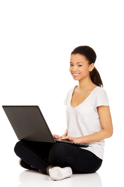 Nastolatka krzyż legged siedząca z laptopem. — Zdjęcie stockowe