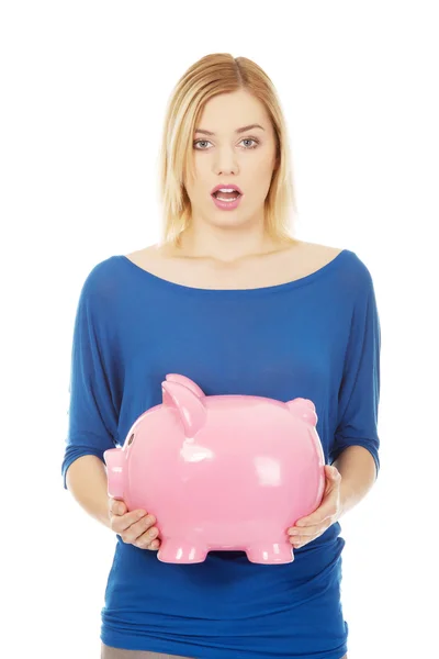 Mujer conmocionada sosteniendo a Piggybank . — Foto de Stock