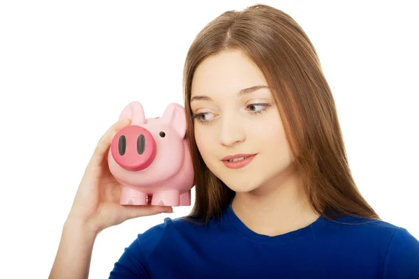 Tizenéves nő gazdaság piggybank. — Stock Fotó