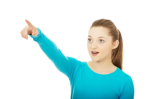 Shocked young woman pointing up. — Stock Photo, Image