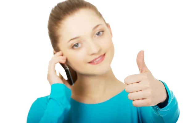 Adolescente com telefone celular e polegares para cima . — Fotografia de Stock