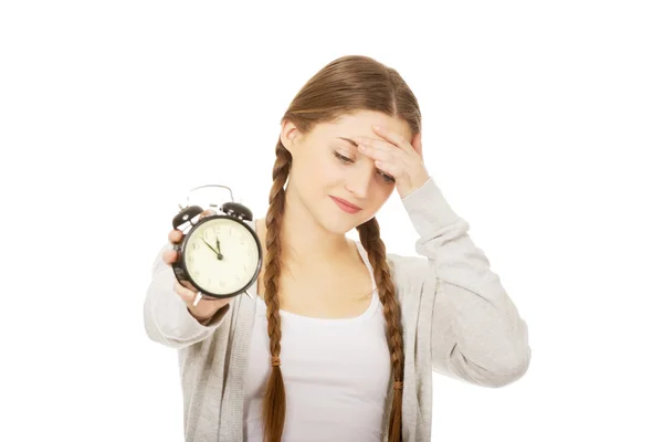 Unavená žena dospívající s alarmclock. — Stock fotografie