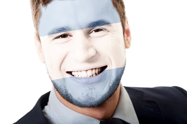 Szczęśliwy człowiek z flagą Argentyny na twarz. — Zdjęcie stockowe