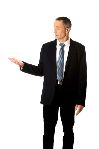 Businessman holding something on his palm — Stock Photo, Image