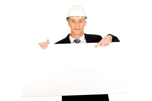 Empresario con sombrero duro sosteniendo banner vacío — Foto de Stock