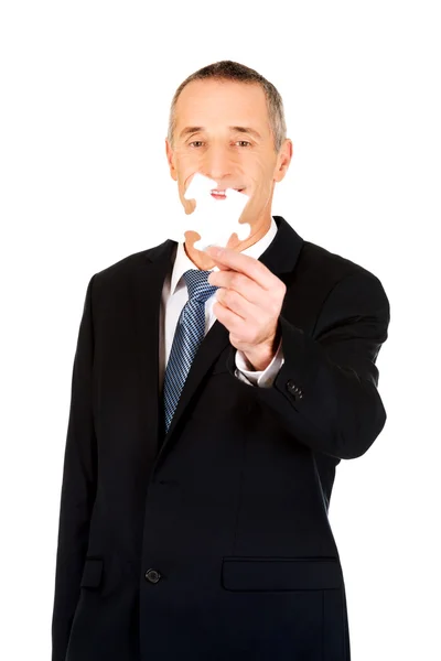 Hombre de negocios inteligente sosteniendo un rompecabezas — Foto de Stock