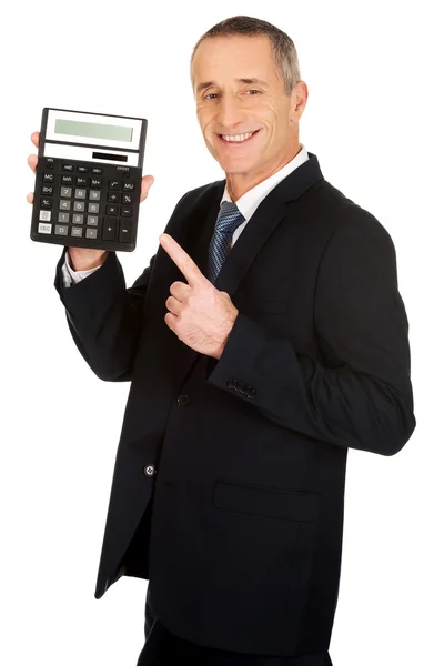 Счастливый бизнесмен указывает на калькулятор — стоковое фото