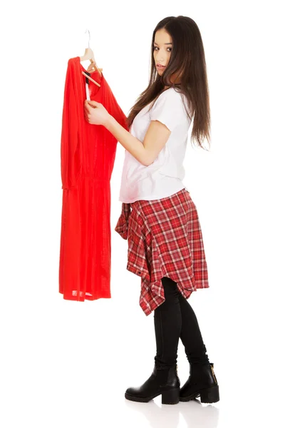 Mulher bonita segurando vestido vermelho . — Fotografia de Stock