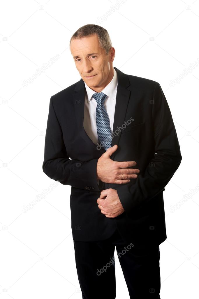 Mature businessman suffering from stomachache