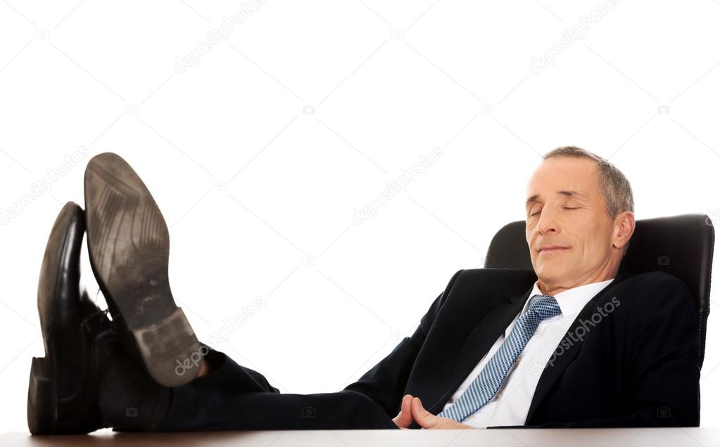 Mature businessman resting in armchair