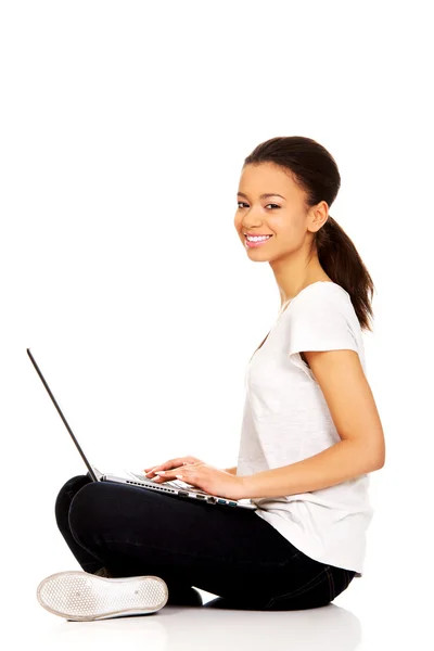 Teen sitting cross legged with laptop. — Stock Photo, Image