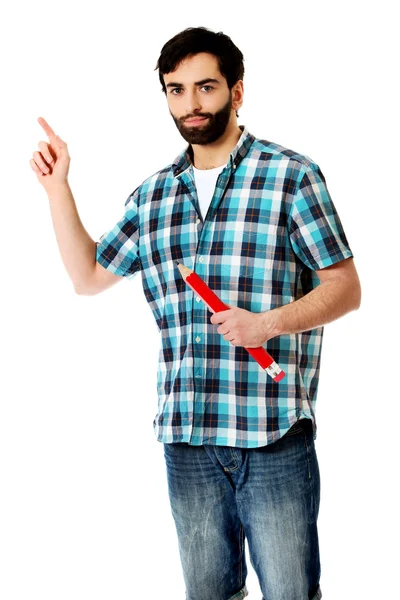 Young man holding big red pencil. — Stock Photo, Image