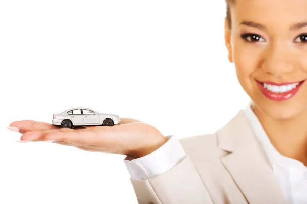 Businesswoman holding small car on palm. — Stock Photo, Image