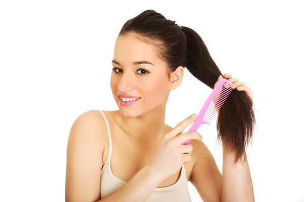 Beautiful woman combs her hair. Royalty Free Stock Photos