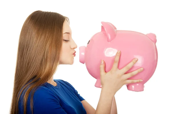 Teenage woman kissing piggybank. — Stock Photo, Image