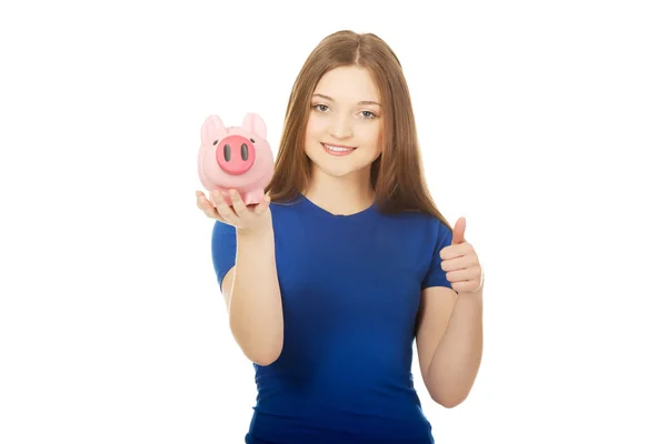 Tonåriga kvinna anläggning piggybank. — Stockfoto