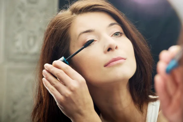 Kvinnan gör ljus dag makeup i badrum. — Stockfoto