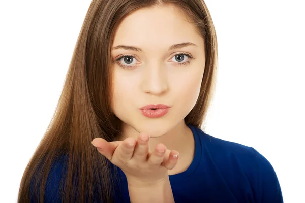 Mooie jonge vrouw blaast een kus. — Stockfoto