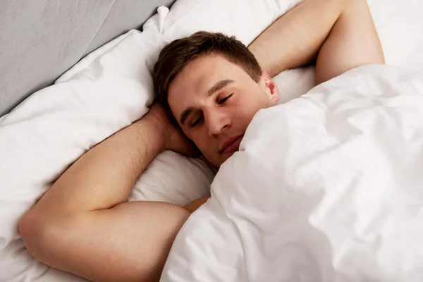 Bonito jovem deitado na cama. — Fotografia de Stock