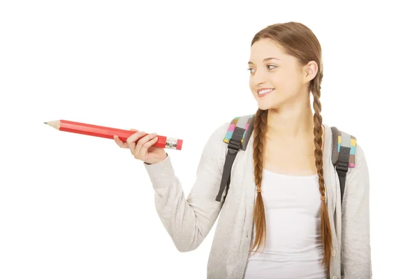 Schoolmeisje wijzen opzij met potlood. — Stockfoto