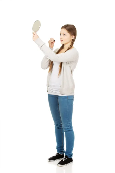 Teen woman applying lipstick looking at mirror. — Stock Photo, Image