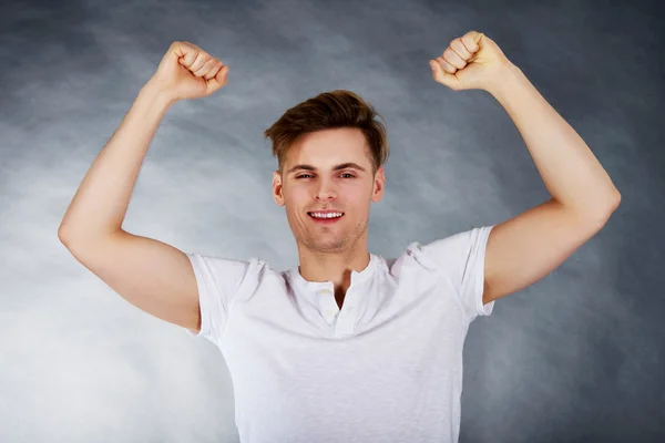 Young man showing winner gesture.