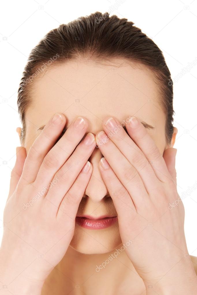 Woman covering her eyes.
