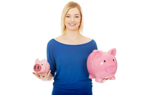 Glückliche Frau hält zwei Sparschweine. — Stockfoto