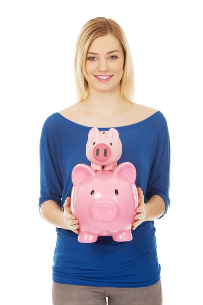Glückliche Frau hält zwei Sparschweine. — Stockfoto