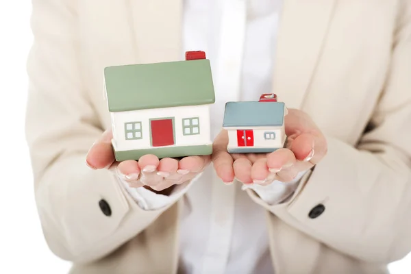 Businesswoman compares two house models. — Stock Photo, Image