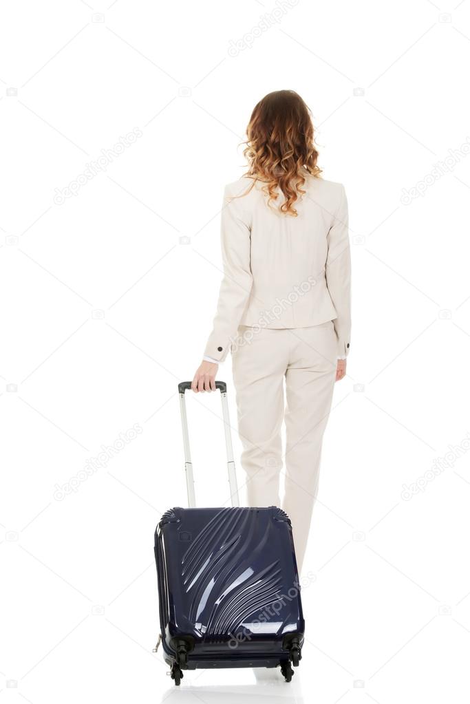Businesswoman dragging suitcase.