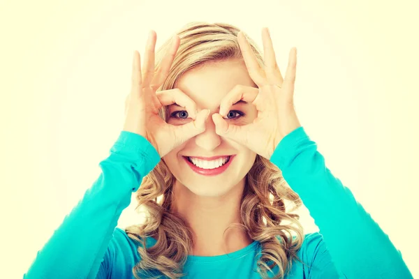 Portrait of a woman showing ok sign on eyes — Stock Photo, Image