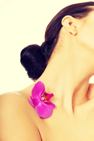 紫色兰花花瓣在肩膀上的女人 — 图库照片