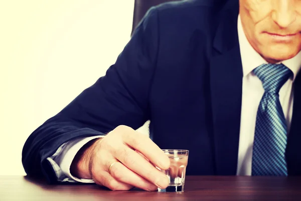 Hombre sobrecargado de trabajo bebiendo vodka en la oficina — Foto de Stock