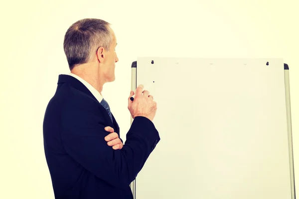 Escrita executiva masculina em um flipchart — Fotografia de Stock