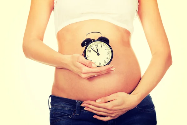 Mulher grávida com um despertador — Fotografia de Stock