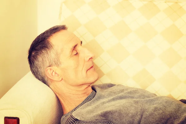 Mature man lying on the sofa — Stock Photo, Image