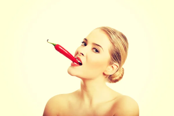 Feliz mujer desnuda sosteniendo chile en su boca — Foto de Stock