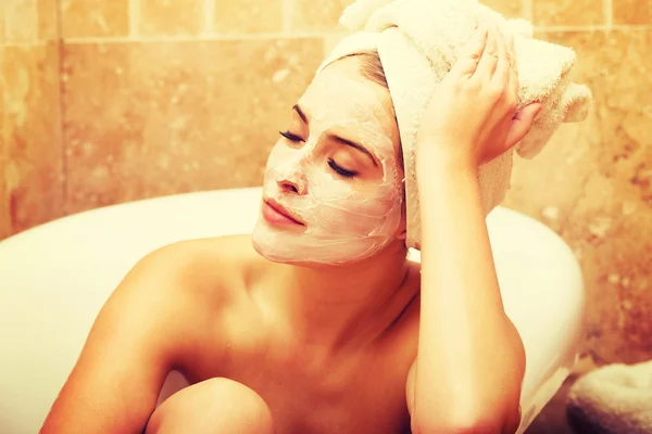 Mulher com creme facial relaxante no banho — Fotografia de Stock