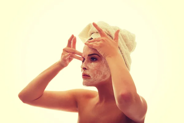 Wanita mengoleskan krim di wajahnya — Stok Foto