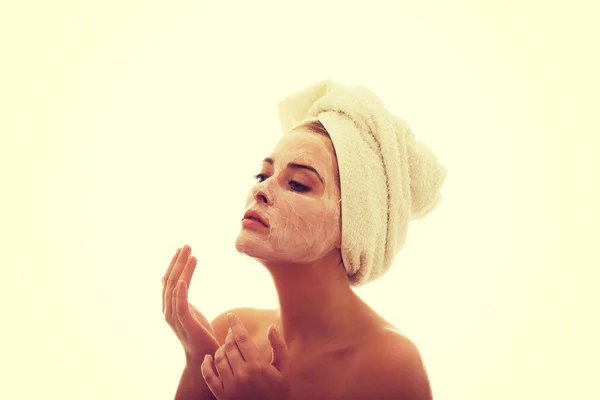 Femme appliquant une crème sur son visage — Photo
